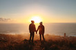 © Jacob Lund - Traveling couple on cliff at sunset