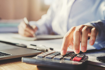 Fototapete - business man working in office and using calculator with pen