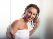 © Yakobchuk Olena - Relaxed and happy. Portrait of beautiful lady with wet hair walking out from bathroom. She is wearing soft towel and looking at camera with smile
