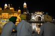 Three sikhs sitting at night in the Golden Temple, the most important temple and pilgrimage site of Sikhism, located in Amritsar, India.
