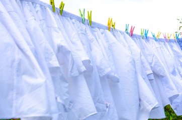 Wall Mural - White shirts hanging outside on a washing line to dry.