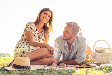 Wall Mural - Couple in love enjoying picnic time and food outdoors