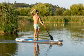 Wall Mural - Man stand up paddleboarding