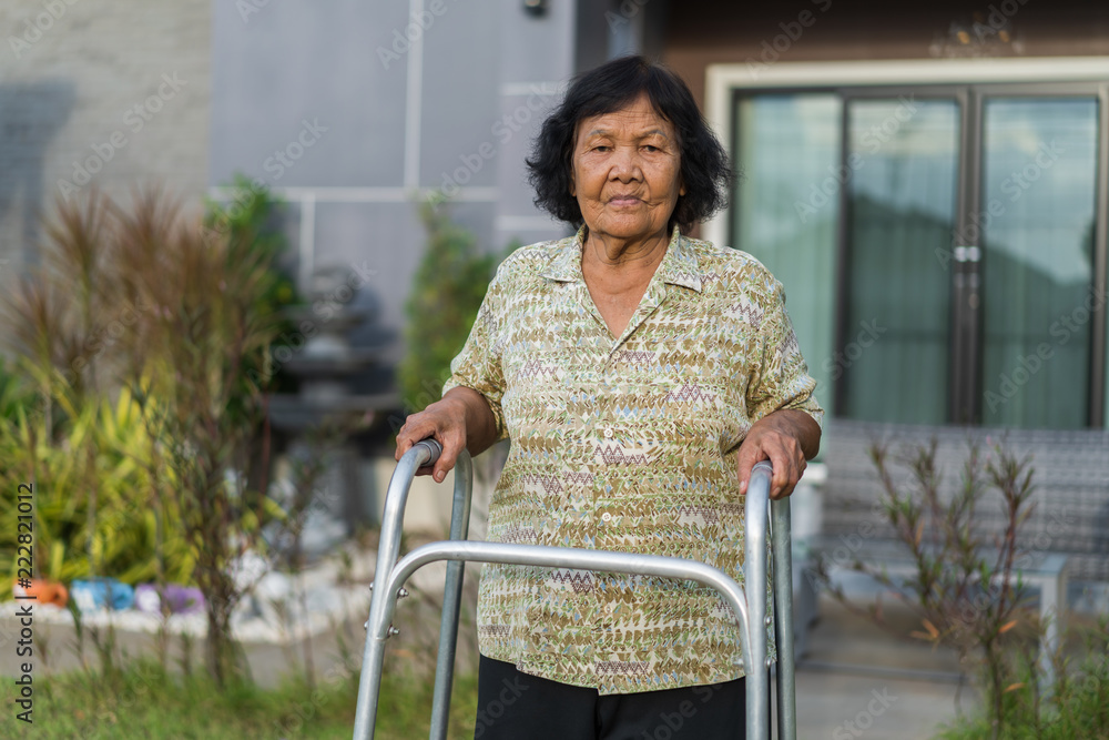 senior woman walking with walker Stock Photo | Adobe Stock