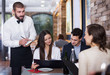Employee waiter man taking order from guests
