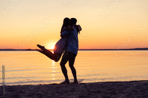 Silhouette Of Happy Couple On Beach At Sunset Man Taking The Girl In His Arms Buy This Stock Photo And Explore Similar Images At Adobe Stock Adobe Stock
