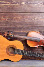 Guitar, Violin And Copy Space. Acoustic Guitar And Violin On Textured Wooden Background. Instruments For Musician.