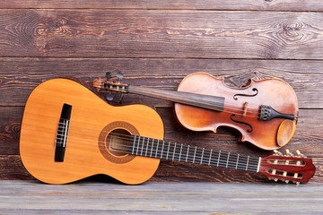 Musical instruments on wooden background. Acoustic guitar and violin. Professional classical equipment for musician.