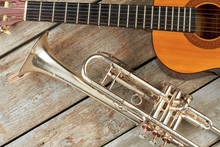 Trumpet And Acoustic Guitar On Wooden Background. Wooden Guitar And Classical Trumpet. Retro Musical Instruments.