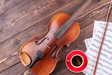 Musical Background With Classical Equipment. Violin, Musical Score Pages And Blank Mug On Wooden Background With Copy Space.