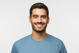 Fototapeta  - Close up portrait of young smiling handsome guy in blue t-shirt isolated on gray background