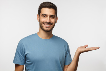 Wall Mural - horizontal portrait of young handsome male isolated on gray background wearing casual blue t-shirt a