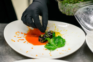 Poster - chef serves a dish with tongue and salad in the kitchen of the restaurant