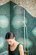 © pressmaster - Young woman in monokini standing under shower sprays in modern spa center