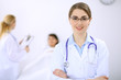 © rogerphoto - Female doctor smiling on the background with patient and his doctor