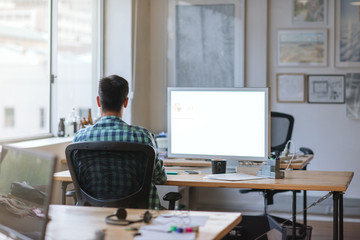 Young designer working late at his desk in an office