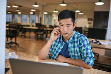 Canvas Print - Young Asian designer working on a computer in an office