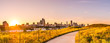 Chicago landscape photo at Northerly Island looking down curved path during beautiful sunset with wildflowers and grass in foreground at golden hour and building skyline at the horizon