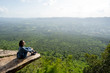 © pigprox - A woman backpacker sits on rock
