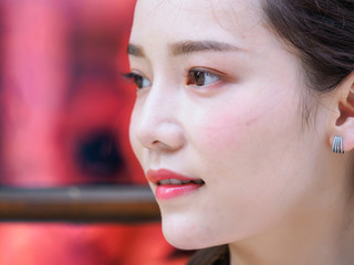 Head shot portrait of beautiful Chinese young woman looking aside, side view, focused on the eyes.