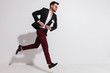 © Viorel Sima - side view of elegant man running and buttoning his suit