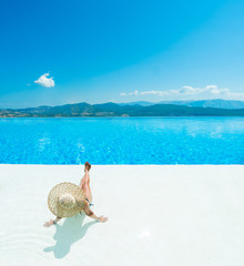 Poster - Woman enjoying relaxation in pool and looking at the view in Santorini