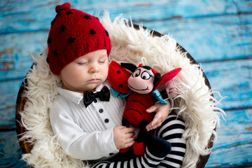 Canvas Print - Little baby boy with knitted ladybug hat and pants in a basket