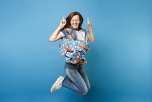 Full Length Portrait Young Overjoyed Woman Student With Closed Eyes With Backpack Jumping Pointing Index Figers Up Isolated On Blue Background. Education In High School. Copy Space For Advertisement.