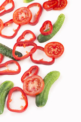 Canvas Print - slices of a cucumber tomato and pepper on a white background