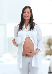 Poster - happy pregnant woman holding Cup of cocoa.