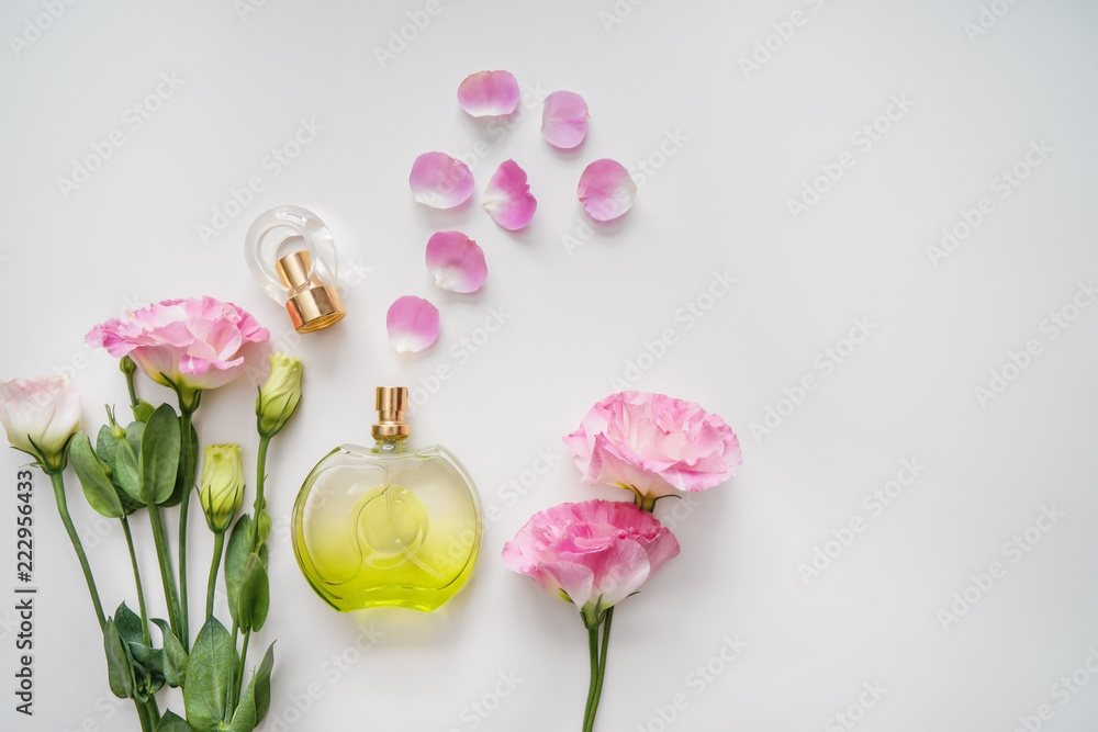 Beautiful composition with bottle of perfume and flowers on white background
