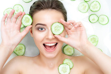 Portrait Of Sexy Beauty Caucasian Female Woman With Clean Pure Skin Taking Spa Relaxing In Bath With Cucumber Slices White Soap Shampoo Water. Skin Beauty Health Care Concept. Body Part Bare Shoulder