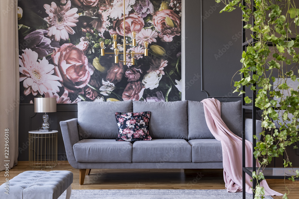 Real photo of a floral living room interior with a wallpaper, sofa and plants - obrazy, fototapety, plakaty 
