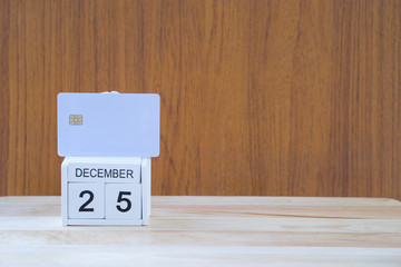 white card on alphabet 25 december with on wooden background,