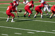 © kpeggphoto - Football Players setting up for the play – Hikes the ball to the quarterback