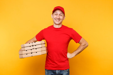 Wall Mural - Delivery man in red cap, t-shirt giving food order pizza boxes isolated on yellow background. Male employee pizzaman or courier in uniform holding italian pizza in cardboard flatbox. Service concept.