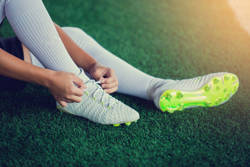 Wall Mural - Soccer players sit and tying sport shoelaces