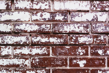 Wall Mural - A photo of the texture of a wall made of red bricks with a partially painted white paint due to weather conditions and time