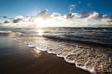 Sand beach and sea waves, Baltic sea seashore during sunset. Curonian spit, Kaliningrad region, Russia