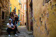 © De Visu - Company of young people sitting on a narrow street of Porto, Portugal.