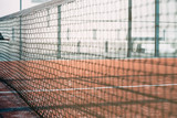 Fototapeta Sport - net in a padel court with orange grass
