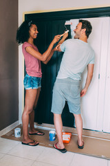 Wall Mural - Interracial couple painting a wardrobe