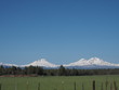 The beautiful Three Sisters in Oregon's Cascade Mountain Range seen from a farm field in Central Oregon
