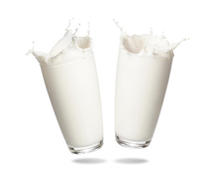 couple milk splashing out of glass isolated on white background.