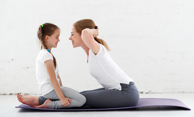 Wall Mural - mother with child practicing yoga in lotus pose .