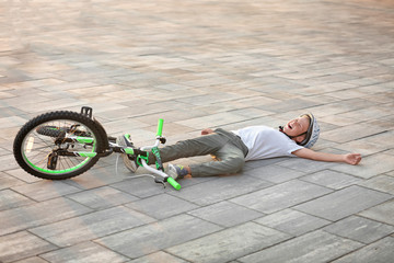 Little boy fallen off his bicycle on street