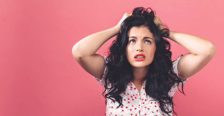Wall Mural - Young woman feeling stressed on a solid background