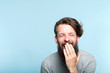emotion expression lol lmfao. very happy joyful exhilarated man laughing out loud. young handsome bearded hipster guy portrait on blue background.
