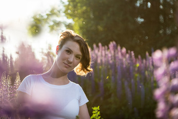 Beautiful girl in a field of purple lupines