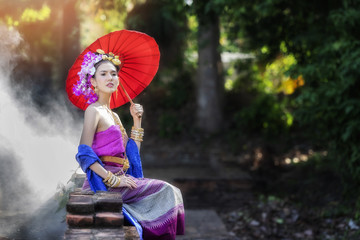 Wall Mural - Beautyful Thai woman wearing thai traditional clothing with red umbrella.